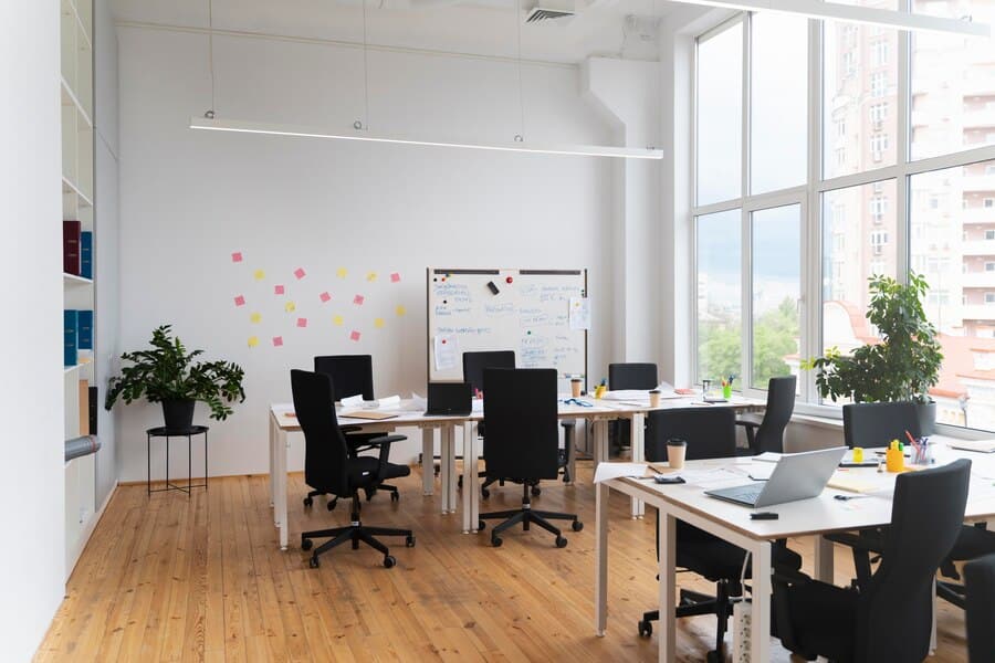Modern office space with desks, chairs, and a whiteboard, emphasizing collaboration and productivity, aligned with SRS Networks' IT solutions for enhancing workplace efficiency.