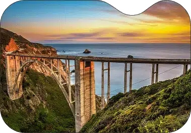 ```json { "alt": "Scenic view of a coastal bridge at sunset with colorful sky.", "title": "Sunset over a coastal bridge" } ```